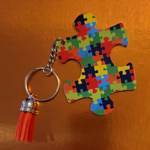 Support those you love with this puzzle design autism keychain with a tassel.