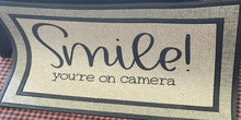 Load image into Gallery viewer, Welcome guest to your home with this heavy duty indoor/ outdoor mat. Tell them to smile because you are watching 🙂, with this Smile You&#39;re on Camera Door mat.  Makes a great housewarming gift, wedding gift, new home owner, or birthday gift.  size: 18 in x 30 in heavy duty and polyester fade resistant simply shake, sweep, or vacuum to clean
